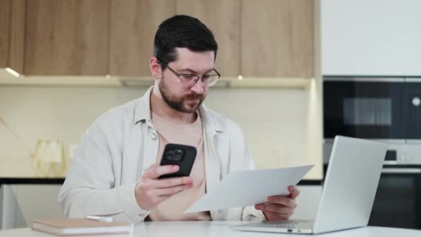 Homem Caucasiano Competente Olhando Documento Para Smartphone Moderno Durante Processo — Vídeo de Stock