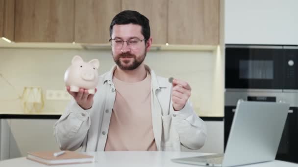 Щасливий Незадоволений Підприємець Сидить Робочому Столі Рожевою Керамічною Грошовою Коробкою — стокове відео