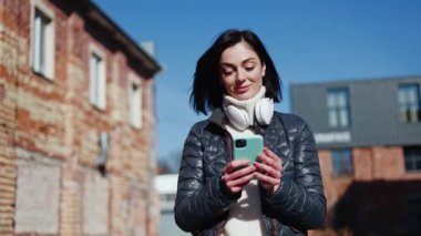Havalı saç stili olan hayalperest bir bayan açık havada yürüyor ve önündeki telefon ekranından kafasını kaldırıyor. Rahat bir kadın, buluşma teklifiyle e-posta alıyor ve kabul etmeyi ya da reddetmeyi düşünüyor..