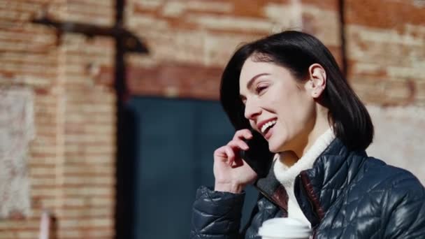 Mutlu Bir Kadının Sokakta Yürürken Akıllı Telefondan Kahvelerle Arkadaşça Sohbet — Stok video