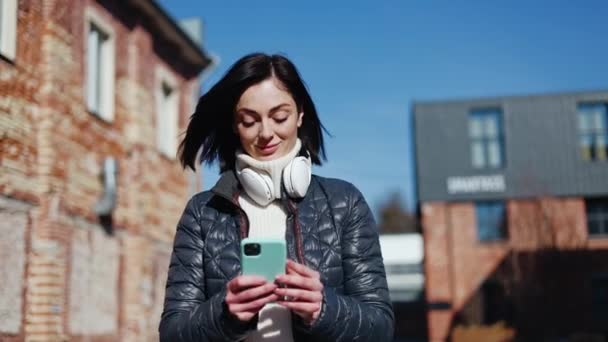 Smiling Caucasian Woman Scrolling Social Media Mobile Gadget While Leaving — Stock Video