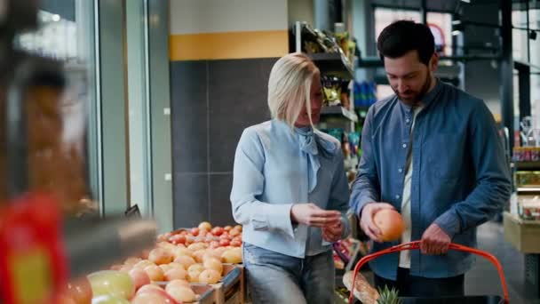 Rodina Stojící Blízkosti Vystavování Ovoce Supermarketu Atraktivní Manželka Drží Pomeranč — Stock video
