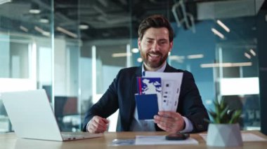 Sırıtkan bir şirket çalışanı, elinde pasaportu ve içinde biniş kartı olan bir koltuğa yaslanıyor. Formalite içindeki memnun adam rüya varış yerine uçuş biletlerinin verilerini kontrol ediyor..