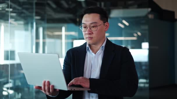 Konzentrierter Asiatischer Mann Offizieller Kleidung Der Laptop Der Hand Hält — Stockvideo