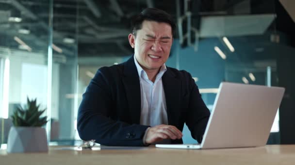 Концентрований Азіатський Чоловік Друкує Ноутбуці Офісі Страждає Від Раптового Болю — стокове відео