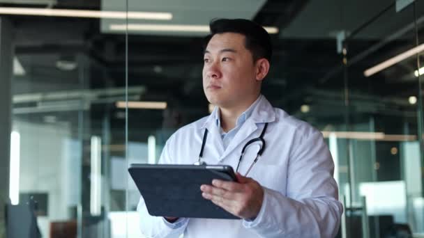 Японский Взрослый Мужчина Медицинской Одежде Стетоскопом Использующий Цифровой Планшет Стоя — стоковое видео