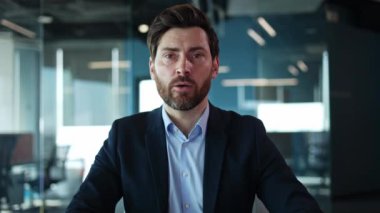 Kamerayla konuşan yakışıklı orta yaşlı bir adamın portresi ve dostane bir gülümsemeyle el sıkışması. Başarılı şirket temsilcisi genç mezunları staj ve çalışma deneyimi için davet ediyor..