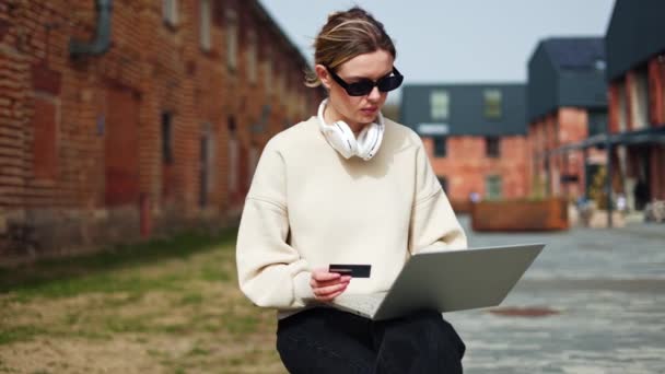 Mulher Séria Segurando Laptop Enquanto Sentado Lugar Urbano Digitando Números — Vídeo de Stock
