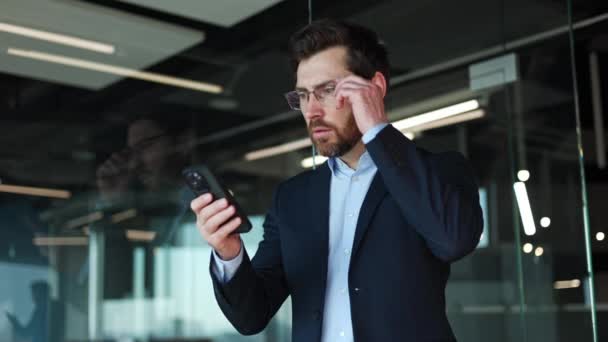 Overrasket Kaukasiske Forretningsmand Fjerne Briller Ser Visning Personlig Smartphone Med – Stock-video