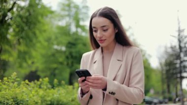 Şık kıyafetli başarılı bir bayan akıllı telefona bakıyor ve kazanan hareketi yaparken evet diye bağırıyor. Piyango kazanacağına inanmayan ve gezintide şanslı bahis oynayan bir kadın..