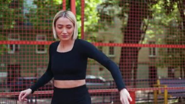 Kaygısız genç kadın basketbol sahasında çalışırken dans ediyor ve eğleniyor..