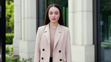 Şık ceketli, ciddi bir beyaz kadın çapraz işaretle ellerini kaldırıyor ve modern yapıya hayır diyor. Israrcı bayan kötü çalışma koşullarına karşı olumsuz tavır sergiliyor..