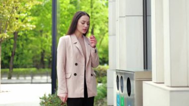Esmer esmer kadın kahve molası sırasında modern ofisin önünde sigara yakmaya hazırlanıyor. Kendine güvenen beyaz kadın dışarıda sağlıklı bir hayat sürüyor. Dayanıklılık kavramı ve insanlar.