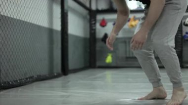 Fit beyaz adam burpee egzersizi yapıyor ve spor salonunda hareket ediyor. Korunaklı zemin örtüsüyle. Genç adam zıplama ve çömelme ile dayanıklılık antrenmanı yapıyor..