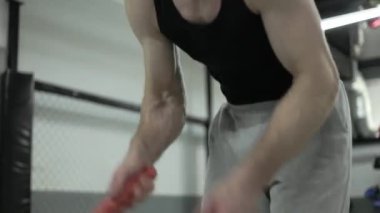 Spor klubünün iç kısımlarında çapraz antrenman sırasında dövüş halatlarıyla egzersiz yapan bitkin erkekleri kapatın. Terli insan yoğun bir eğitim alıyor ve dayanıklılığını artırmak için çaba sarf ediyor..