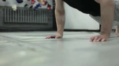 Tahta pozisyonda duran beyaz erkeğin yaklaşın ve spor minderinde dirseklerini bükerken vücudunu aşağı indirin. Çalışkan adam temel egzersize başlamadan önce kasları ısıtmak için egzersiz yapıyor..