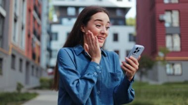 Heyecanlı genç bayan dışarıda yürürken telefonundan harika haberler alıyor..