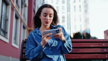 Mutlu genç bir kadın, açık havada gezici bir oyun oynamaya kendini kaptırmış durumda, yarışmanın heyecanını gösteren neşeli tepkileri....