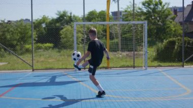 Oyuncu çocuk, futbol topunun spor sahasının zeminine düşmesini engellemeye çalışırken nesne koordinatlarını takip ediyor. Tutkulu genç, sahnelenen hit şarkılar üzerinde çalışıyor..