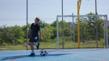 Futbol takımı üniformalı bir genç, topun yanında zıplama antrenmanı yapıyor ve antrenman sırasında edinilen becerileri gösteriyor. Okul şampiyonluğundan önce stadyumda hobi yapan ilginç bir adam..