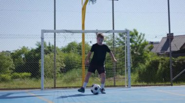 Siyah beyaz topla zıplama ve bacak kaldırma egzersizleri yapan tam uzunlukta bir erkek çocuk. Yerel stadyumdaki okullar arası şampiyonluk için kaslarını hazırlayan aktif bir adam..