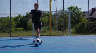 Genç çocuk kaleci olmadan topa vuruyor ve son bir deneme için geri dönüyor. Aktif genç sportif hobiyi seviyor ve maçta profesyonel futbolcu rolü yapıyor..
