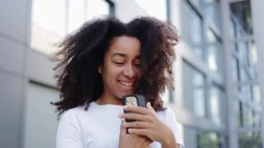 Güzel Latin kadının portresi modern elektronik cihaza sarılıyor ve gür saçlarını mutlu bir ifadeyle sallıyor. Sevimli bayan uzun zamandır beklenen beğeni ve yorum bildirimini blogunda alıyor.