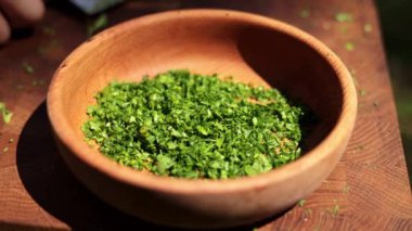 Kırsal ahşap bir kasede taze kesilmiş otlar, lezzetli bir yemekte kullanılmaya hazır..