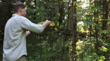 Bir adam ormanda yürür ve bir kağıt tabağı atar, çevreyi kirletir..