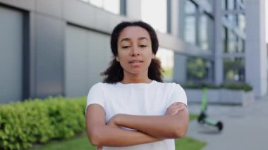 Belinde çapraz kolları olan kendine güvenen bir kadın iş merkezinde kameraya gülümsüyor. Yüzünde hoş bir ifade olan zeki bir bayan ileriye bakıyor ve pozitif enerji saçıyor..
