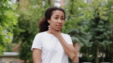Afro-Amerikalı kadın dışarıda dolaşırken boğaz ağrısı çekiyor. Yorgun bir kadın boynuna dokunuyor ve sokakta doktora ihtiyaç duyduğunu fark ediyor. Tedavi kavramı.