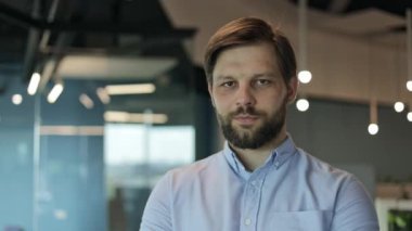 Ofis ortamında kameraya gülümseyen bir iş adamının portresi. İyi görünümlü genç lider erkek işadamı ofis geçmişinde fotokopi alanı var. Profesyonel uzman patron lideri..