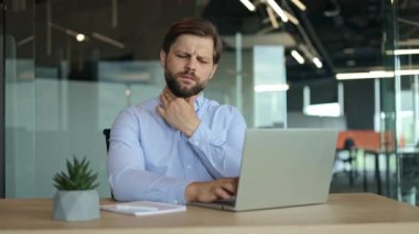 Ofiste dizüstü bilgisayarla çalışırken boğazı ağrıyan bir iş adamı. Hasta adam boğaz ağrısı, yutkunma ağrısı, bademcik iltihabı, tahriş olmuş erkek hasta tiroid bezini tek başına kontrol et.