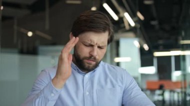 Yorgun iş adamı iş yerinde baş ağrısı çekiyor. Stresli ve iş yorgunluğu çekiyor. Başı ağrıyan, bitkin düşmüş ya da stresli bir iş adamı kriz, yorgunluk ya da depresyonda..