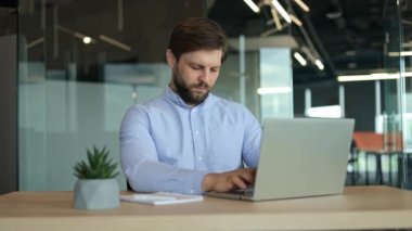 Yorgun iş adamı masasında uyanık kalmak için çabalıyor, esniyor ve esniyor..