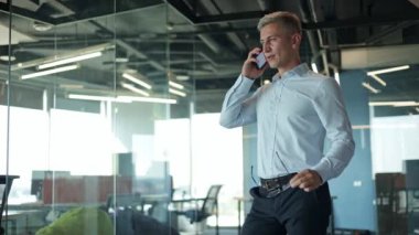 Ofiste telefonla konuşan dost canlısı bir iş adamı. Ofis penceresinin yanında bekleyen mutlu Ceo aramaları. Kendine güvenen yönetici telefon görüşmesi yapar..