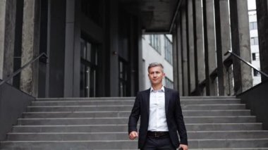 Takım elbiseli, kendinden emin bir iş adamı bir ofis binasından merdivenlerden aşağı iniyor. Gülümsüyor ve kameraya bakıyor. Bu klip başarı, liderlik ve kararlılık temalarını çağrıştırıyor.