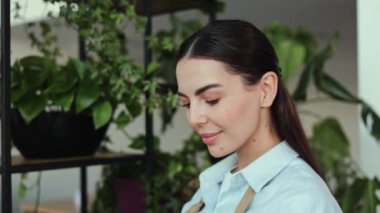 Mutlu ve kendinden emin bir küçük işletme sahibi kameraya gülümsüyor. Etrafı yeşilliklerle çevrili olan fabrikasının içinde. Kız önlük giyiyor ve müşterilerine yardım etmeye hazır..