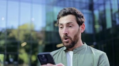 Bir ofis binasının önünde duran mutlu bir işadamı telefonundan iyi haberler alır, zaferi ve başarıyı yavaş çekimde kutlar..