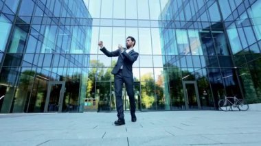 Mutlu, başarılı bir iş adamı, güneşli bir günde ofisin dışında komik bir dansla kutlama yapar. Heyecanlı ve neşeli..