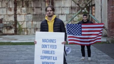 İki genç adam protesto yapıyor, biri 