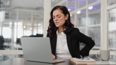 Ofiste dizüstü bilgisayarla çalışırken sırt ağrısı çeken genç bir iş kadını. Boyun ağrısı, sırt ağrısı, omurga sorunu. Uzun bir işten sonra yorgun bir çalışan. Yorgun kadın yönetici masajı belden aşağısı.