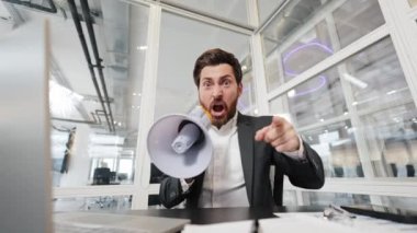 Kızgın işadamı ofisteki bir megafona bağırıyor. Parmağını kameraya doğrultuyor. Stres, öfke ve iş konuları.