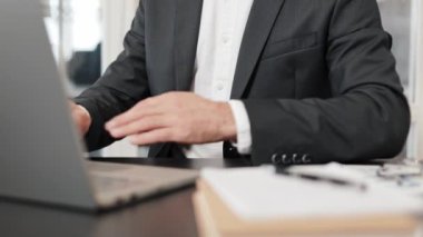 Takım elbiseli bir işadamı masasında oturmuş dizüstü bilgisayarı üzerinde çalışırken aniden midesi ağrımaya başladı. Mide ağrısı ya da hazımsızlık çekiyor..