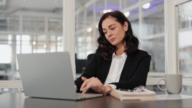 Sıkıcı uykuya dalan iş kadını dizüstü bilgisayarda yazarken masasında esniyor. Kadın yorgun ve çok çalışıyor..