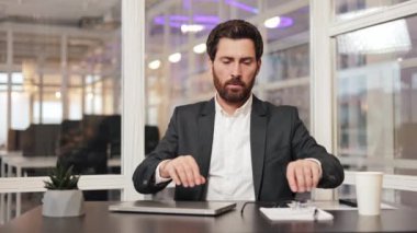 Yoğunlaşmış işadamı veya ofis çalışanı gözlük takar, bir dizüstü bilgisayar açar ve bir proje üzerinde çalışmaya başlar. Müdür, şirketlerin büyümesi için bir pazarlama stratejisi geliştirmeye odaklanmış durumda..