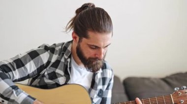 Evde akustik gitar çalan yakışıklı bir müzisyen. Oturma odasında şarkı besteleyen yetenekli bir serbest yazar. Genç sanatçı içeride müzik yaratmaktan hoşlanıyor.