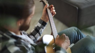 Yetenekli müzisyen evde akustik gitar çalar. Profesyonel serbest yazar müzikten hoşlanır. Yaratıcı sanatçı oturma odasında bir şarkı besteler..