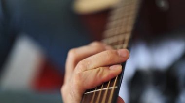 Evde akustik gitar çalan profesyonel müzisyenlere yakın çekim. Yetenekli sanatçı içeride müzik yaratıyor. Güzel müzikler odayı dolduruyor..