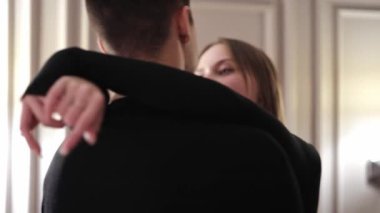 Siyah elbiseli güzel çift evde nazikçe birbirlerine sarılıyorlar. Tutkulu kadın ve yakışıklı erkek şefkat ve sevginin tadını çıkarıyorlar. Romantik kapalı tarih.